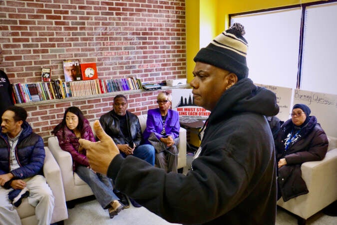 Rueben Jones, founder of Frontline Dads, calls on other anti-gun violence groups to make a committment to work together during a meeting in North Philadelphia. (Emma Lee/WHYY)