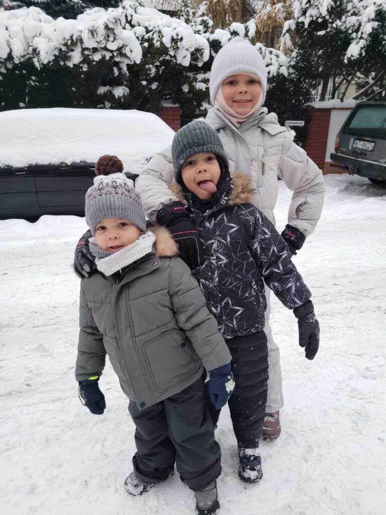 (From left) Taras. age 3, Nazar, 4, and Zoryana, 8, play in the snow near their new home in Warsaw