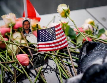 Mourners place flowers over the names of the victims of the 1993 World Trade Center bombing during a ceremony at the 9/11 Memorial