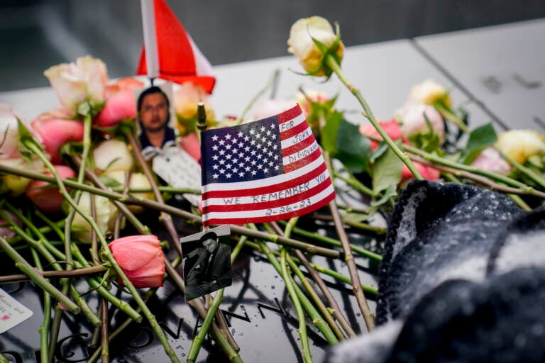 Mourners place flowers over the names of the victims of the 1993 World Trade Center bombing during a ceremony at the 9/11 Memorial