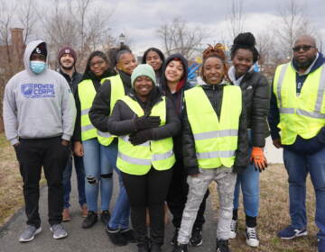 A group of people in yellow reflective vests pose for a photo outdoors.