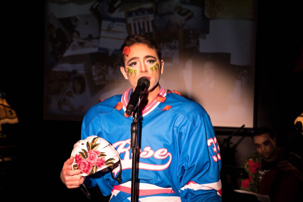 A performer speaks into a microphone onstage.