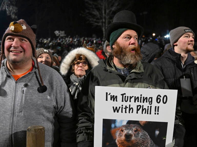 Rory Szwed, left, and Kent Rowan watch the festivities while waiting for Punxsutawney Phil to make his prediction at Gobbler's Knob in Punxsutawney, Pa., early Thursday morning. (Barry Reeger/AP)