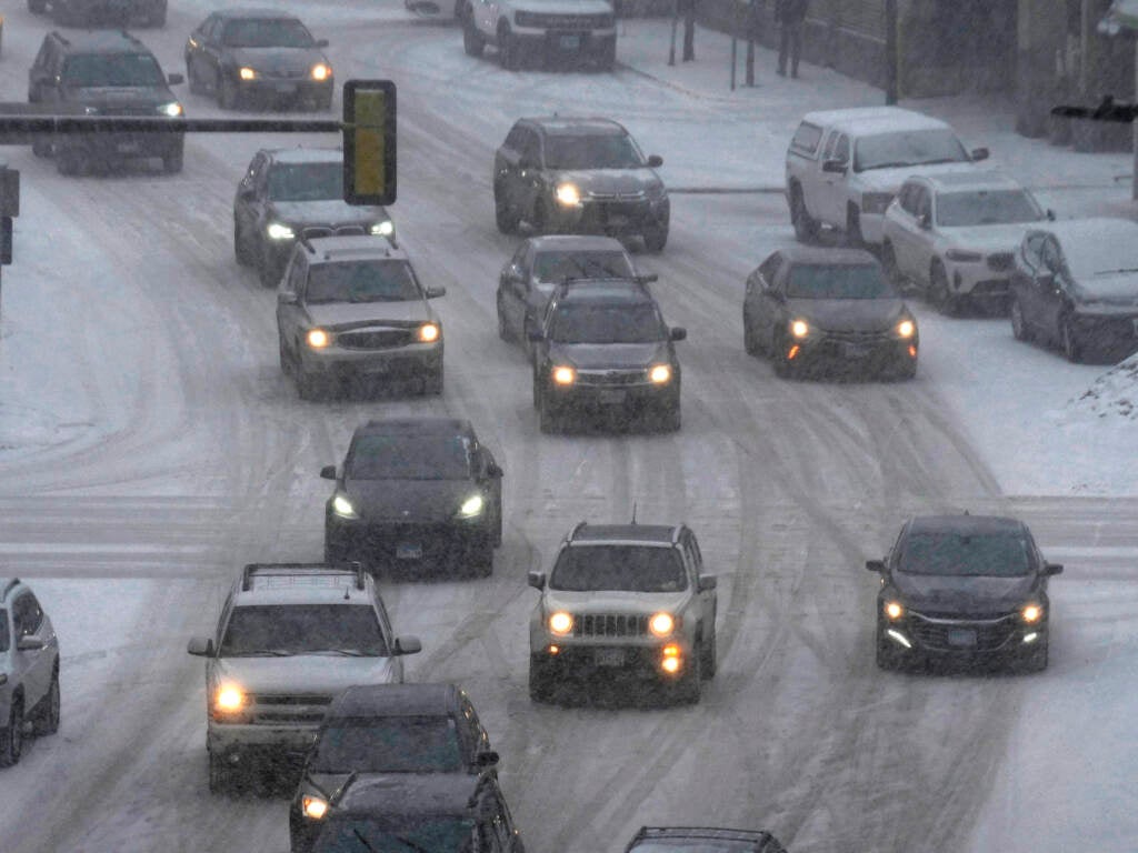 Vehicles drive in downtown Minneapolis as snow falls Tuesday. A winter storm took aim at the Upper Midwest on Tuesday, threatening to bring blizzard conditions, bitterly cold temperatures and 2 feet of snow