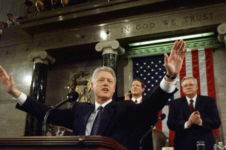 President Clinton gives a speech from a podium.