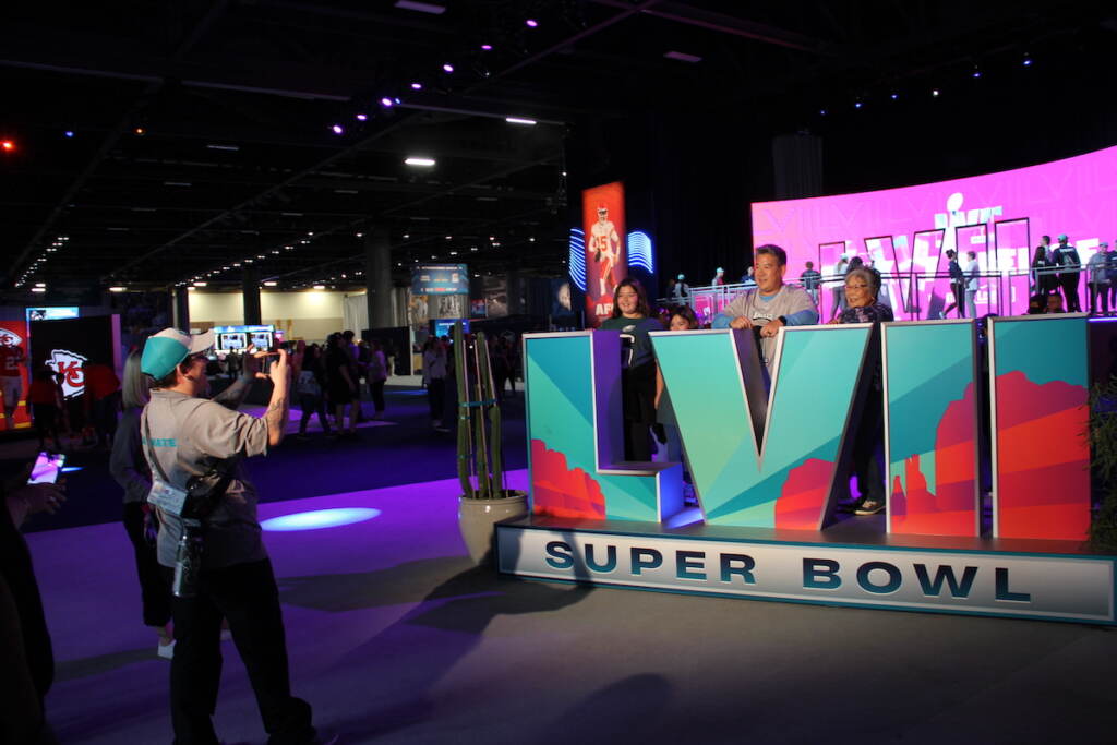 People pose for a photo with a sign that reads LVII Super Bowl.