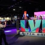 People pose for a photo with a sign that reads LVII Super Bowl.