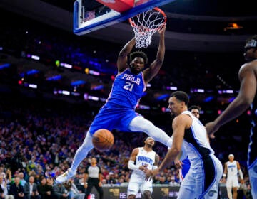 Embiid does a slam dunk.