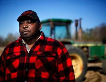 Lucious Abrams, a plaintiff in the Pigford v. Glickman class action lawsuit, stands in front of a tractor on his Georgia farm