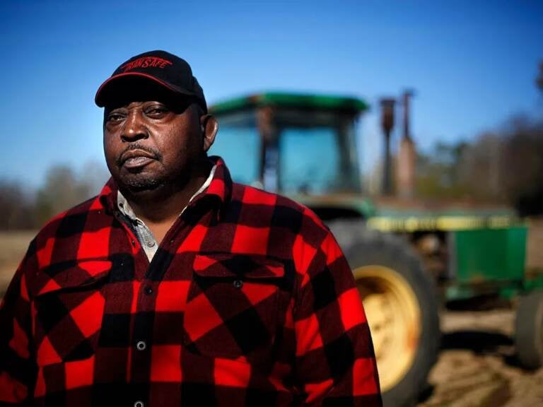 Lucious Abrams, a plaintiff in the Pigford v. Glickman class action lawsuit, stands in front of a tractor on his Georgia farm