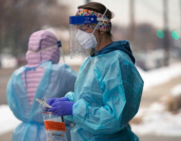 A nurse prepares for a COVID-19 test outside the Salt Lake County Health Department, Dec. 20, 2022, in Salt Lake City. The declaration of a COVID-19 public health emergency three years ago changed the lives of millions of Americans by offering increased health care coverage, beefed up food assistance and universal access to coronavirus vaccines and tests. Much of that is now coming to an end, with President Joe Biden's administration saying it plans to end the emergencies declared around the pandemic on May 11, 2023. (AP Photo/Rick Bowmer, File)