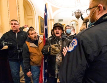 File photo: Kevin Seefried, second from left, holds a Confederate battle flag as he and other insurrectionists loyal to President Donald Trump are confronted by U.S. Capitol Police officers outside the Senate Chamber inside the Capitol in Washington, Jan. 6, 2021. A federal judge on Wednesday, June 15, 2022, convicted Kevin Seefried and his adult son Hunter Seefried of charges that they stormed the U.S. Capitol together to obstruct Congress from certifying President Joe Biden’s 2020 electoral victory. (AP Photo/Manuel Balce Ceneta, File)