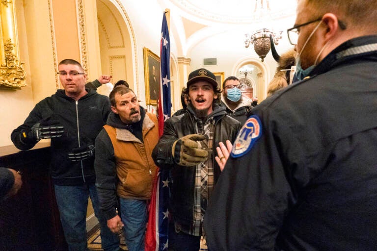 File photo: Kevin Seefried, second from left, holds a Confederate battle flag as he and other insurrectionists loyal to President Donald Trump are confronted by U.S. Capitol Police officers outside the Senate Chamber inside the Capitol in Washington, Jan. 6, 2021. A federal judge on Wednesday, June 15, 2022, convicted Kevin Seefried and his adult son Hunter Seefried of charges that they stormed the U.S. Capitol together to obstruct Congress from certifying President Joe Biden’s 2020 electoral victory. (AP Photo/Manuel Balce Ceneta, File)