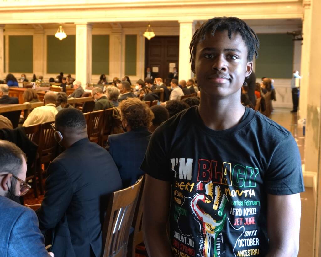 Khyree Counsins, smiling, poses for a photo in City Council chambers.