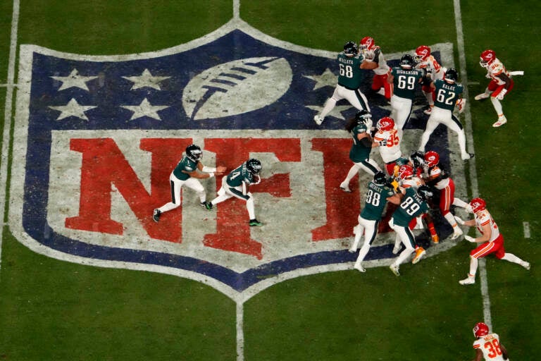 Philadelphia Eagles quarterback Jalen Hurts, left, hands off to running back Kenneth Gainwell during Super Bowl LVII
