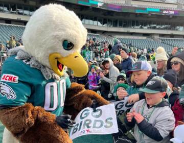 Philadelphia Eagles mascot Swoop signs an autograph for a young Eagles fan during the Philadelphia Eagles Super Bowl Send-off Party. (Jetta M. Holiday/WHYY)