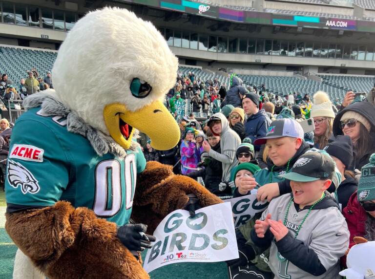 Philadelphia Eagles mascot Swoop signs an autograph for a young Eagles fan during the Philadelphia Eagles Super Bowl Send-off Party. (Jetta M. Holiday/WHYY)