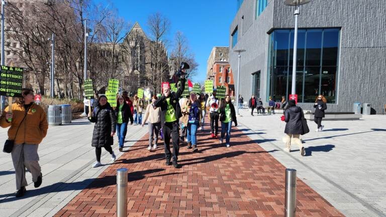 Striking grad student teachers walk on Temple's campus.