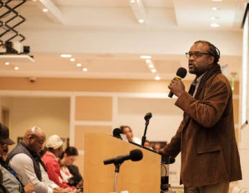 A person speaks at a podium in front of an audience.