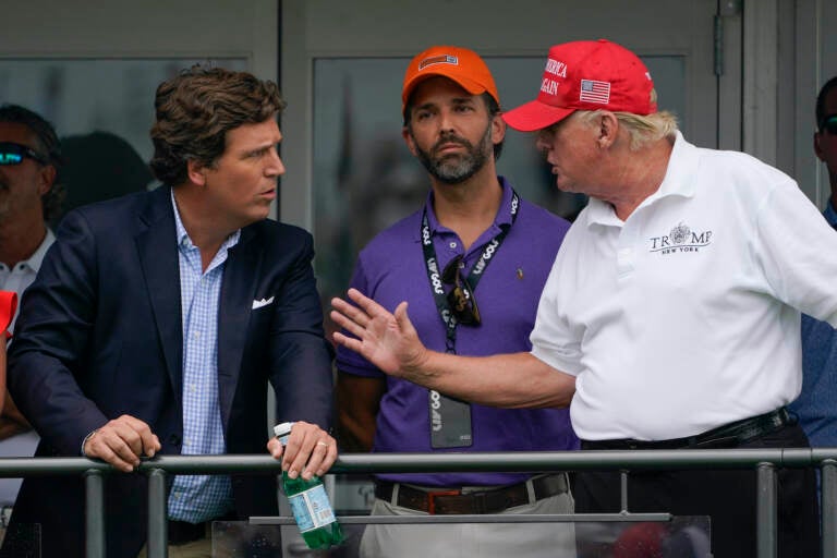 Tucker Carlson speaking with Donald Trump and Donald Trump Jr.