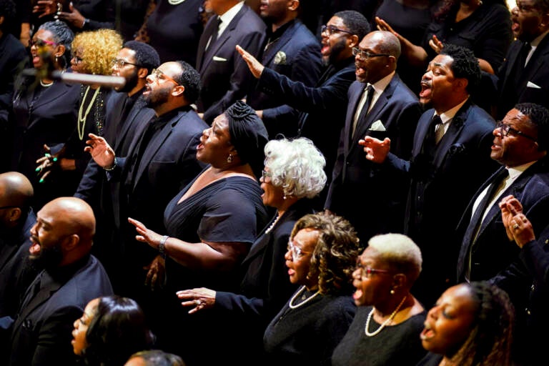 A choir sings, dressed in black.
