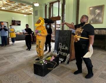 A group performs a skit at the front of a room.