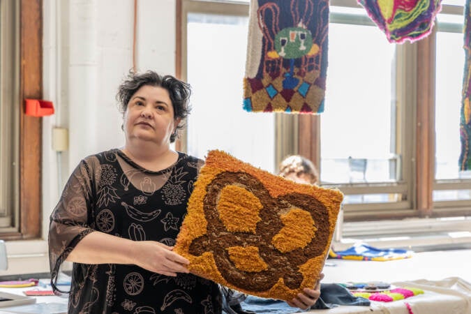 Tiernan Alexander displays a tufted artwork.