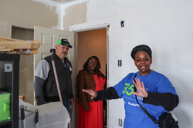 Andrea Johnson shows a room under repair to Councilmember Kendra Brooks and another person.