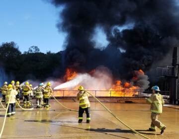 Firefighters contain a blaze as part of a Delaware State Fire School exercise