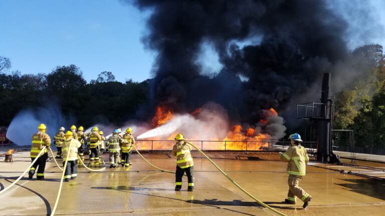 Firefighters contain a blaze as part of a Delaware State Fire School exercise