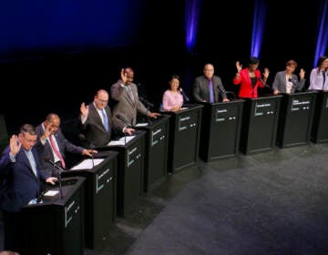 Candidates for mayor of Philadelphia raise their hands when asked who has a TikTok account. The question came during a forum on the performing arts and cultural economy at the Kimmel Center. The candidates are (from left) Jeff Brown, Jimmy DeLeon, Allan Domb, Derek Green, Helen Gym, David Oh, Cherelle Parker, Maria Quiñones Sánchez, and Rebecca Rhynhart. (Emma Lee/WHYY)