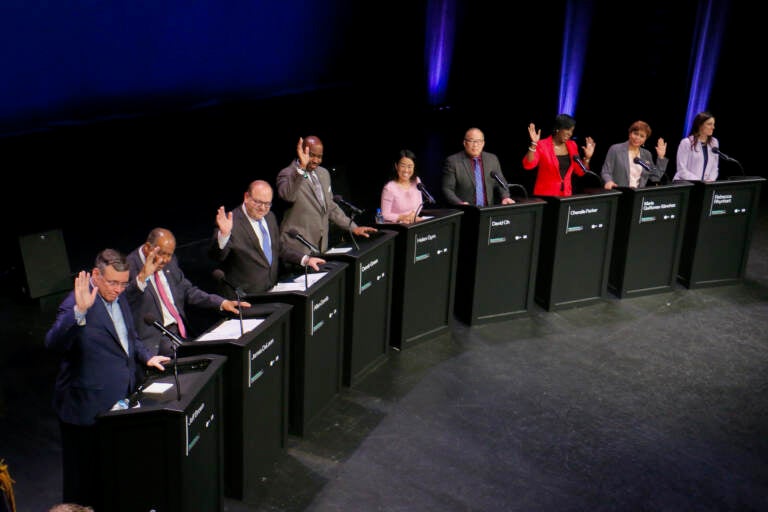 Candidates for mayor of Philadelphia raise their hands when asked who has a TikTok account. The question came during a forum on the performing arts and cultural economy at the Kimmel Center. The candidates are (from left) Jeff Brown, Jimmy DeLeon, Allan Domb, Derek Green, Helen Gym, David Oh, Cherelle Parker, Maria Quiñones Sánchez, and Rebecca Rhynhart. (Emma Lee/WHYY)