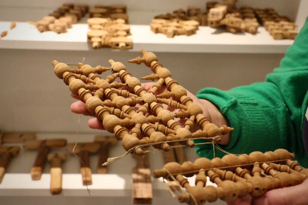 A close-up. of Jennifer-Navva Milliken's hands holding pieces of mashrabiya woodwork.