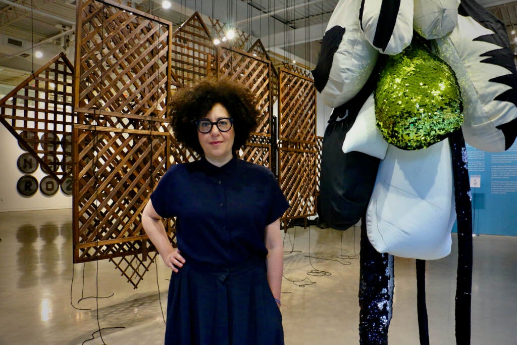 Hoda Towakol poses next to her artwork.