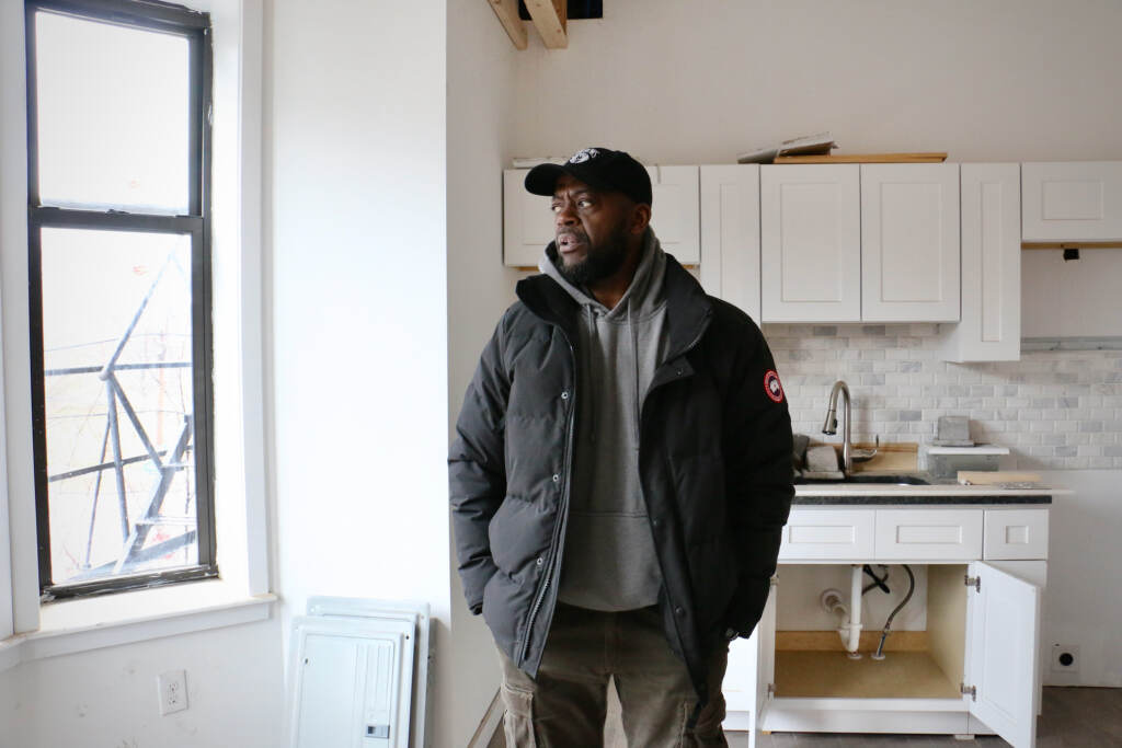 Dawud Bey stands in an unfinished studio apartment in a historic building in West Philadelphia