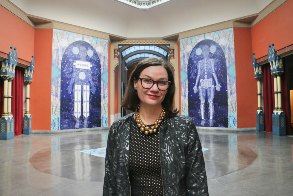 Anna Marley stands in front of artwork.