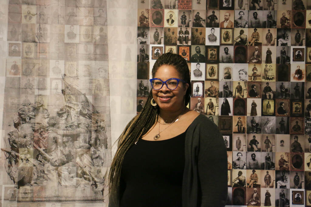 Dejay Duckett stands in front of artwork.