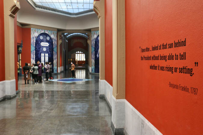 A quote is visible on a wall leading to the lobby of a museum.