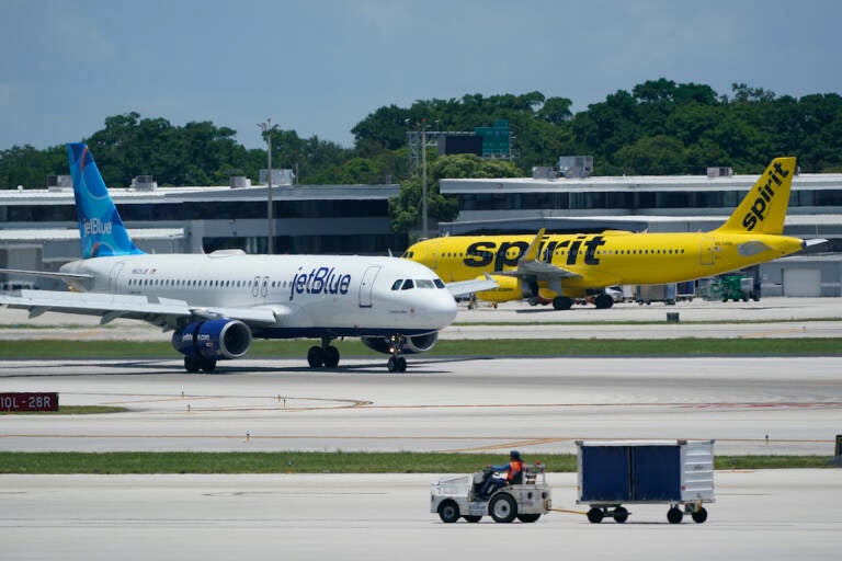 File photo: A JetBlue Airways Airbus A320, left, passes a Spirit Airlines Airbus A320 as it taxis on the runway, July 7, 2022, at the Fort Lauderdale-Hollywood International Airport in Fort Lauderdale