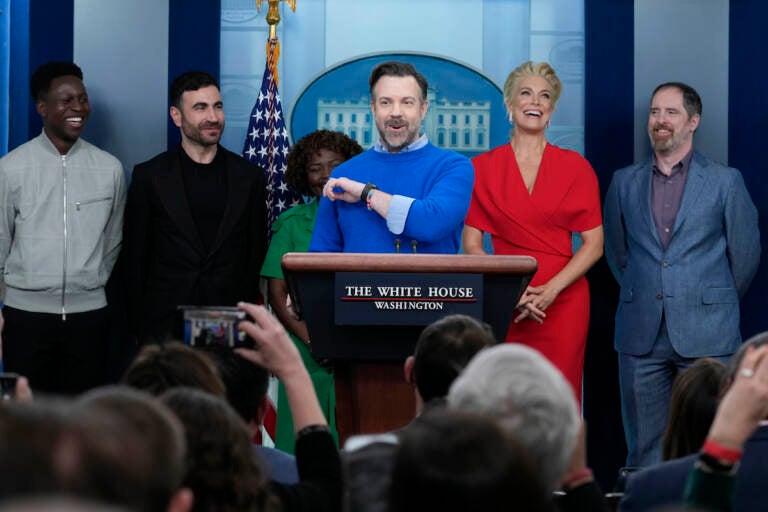 Jason Sudeikis (fourth from left) who plays the title character in the Apple TV+ series ''Ted Lasso,'' speaks as he joins White House press secretary Karine Jean-Pierre (third from left) and fellow cast members (from left) Toheeb Jimoh, Brett Goldstein, Hannah Waddingham, and Brendan Hunt, during the daily press briefing at the White House in Washington