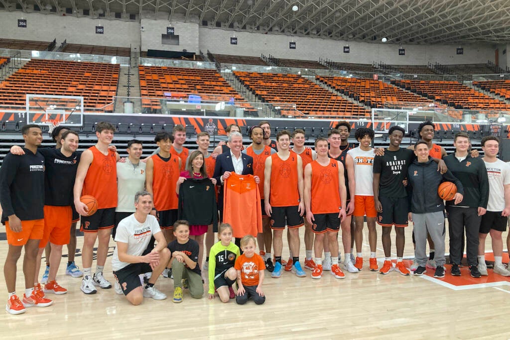 New Jersey governor Phil Murphy and his wife, Tammy, pose with members of the Princeton NCAA college basketball team in Princeton, N.J., Tuesday, March 21, 2022. Head coach Mitch Henderson kneels at front left. Princeton plays Creighton in a Sweet 16 college basketball game at the NCAA South Regional of the NCAA Tournament on Friday in Louisville, Ky. (AP Photo/Dan Gelston)