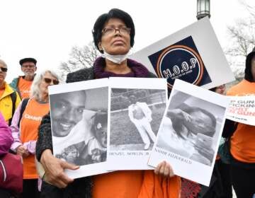 A woman holds photos of gun violence victims at a rally at the Pennsylvania Capitol pressing for stronger gun-control laws, Thursday, March 23, 2023, in Harrisburg, Pa.