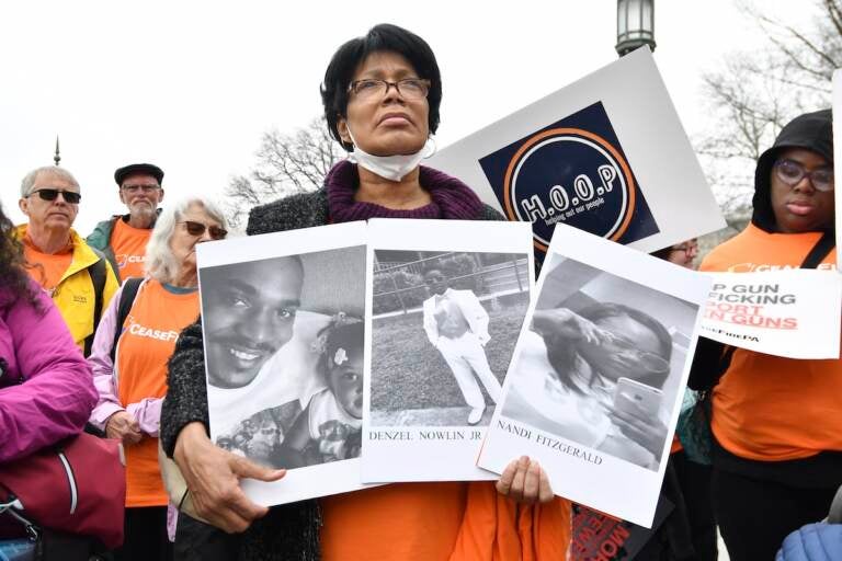 A woman holds photos of gun violence victims at a rally at the Pennsylvania Capitol pressing for stronger gun-control laws, Thursday, March 23, 2023, in Harrisburg, Pa.