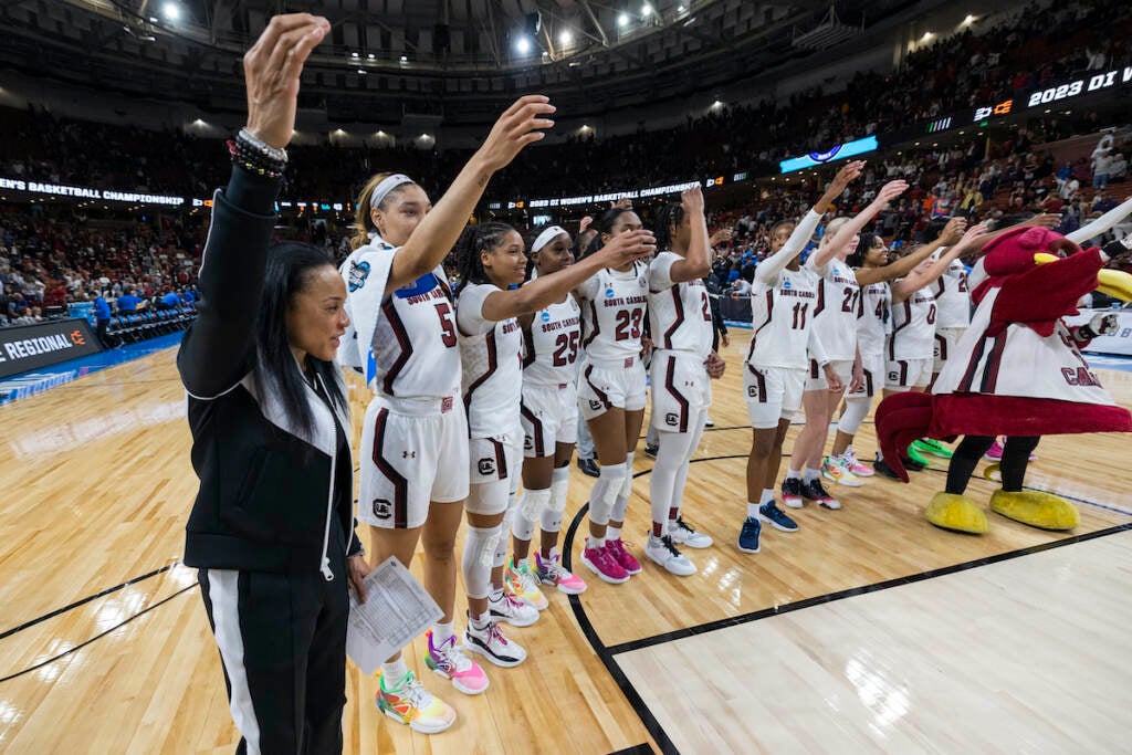 South Carolina's head coach Dawn Staley (far left) celebrates with her players after they defeated UCLA to advance to the Elite Eight following a Sweet 16 college basketball game at the NCAA Tournament in Greenville