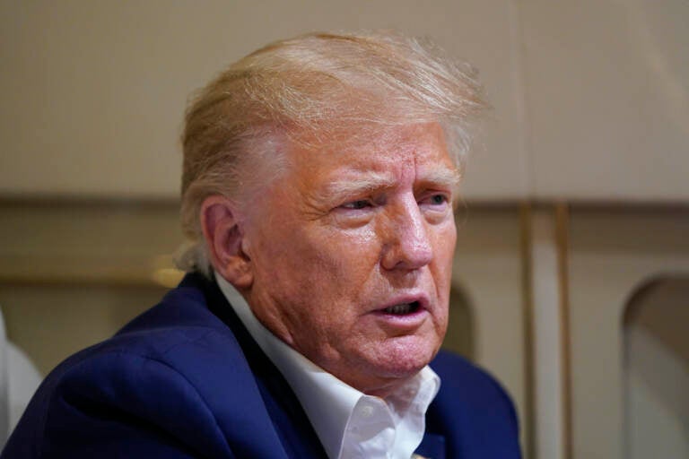 Former President Donald Trump speaks with reporters while in flight on his plane after a campaign rally at Waco Regional Airport, in Waco, Texas, Saturday, March 25, 2023, while en route to West Palm Beach