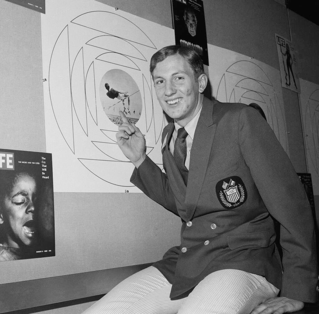 Dick Fosbury, who won a gold medal at the 1968 Olympic games in Mexico city with an Unorthodox jumping style, is shown on Jan. 6, 1969 in New York City with a photo of himself using the style, Known as the ''Fosbury Flop.'' Fosbury goes over the bar backwards while the standard way is to go over face down with the body parallel to the bar