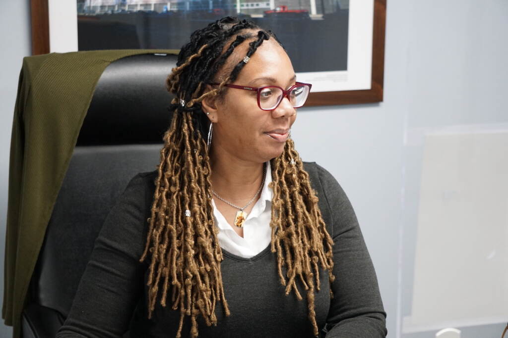 Maxayn Gooden sits at a desk in an office, looking off to the side.