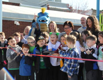 Kids got to cut the ribbon to celebrate Glavin Playground's reopening on March 16, 2023. (Cory Sharber/WHYY)
