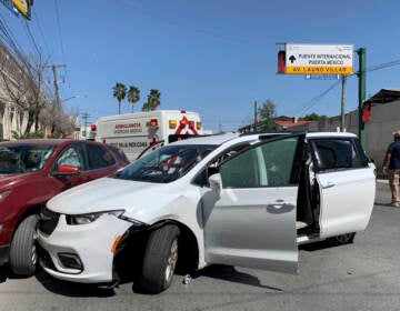 A member of the Mexican security forces stands next to a white minivan with North Carolina plates and several bullet holes at the scene of the crime in Matamoros on Friday. (STR/AP)