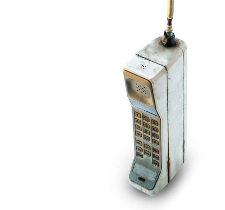 Close up rustic vintage mobile phone isolated on white background